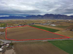 Overview of rural landscape with property parcel outlined and a mountain backdrop