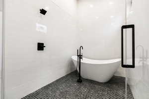 Bathroom featuring a freestanding bath, tile walls, and tile patterned flooring