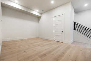 Basement flex/family room featuring light wood-type flooring, recessed lighting, and stairs