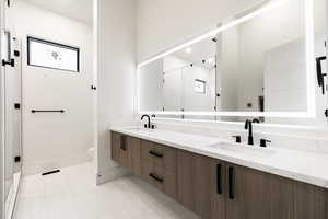 Bathroom with double vanity, and lighted mirror