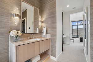 Bathroom featuring vanity, light carpet, recessed lighting, and a chandelier