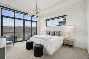 Carpeted bedroom with tile walls, access to outside, a chandelier, and expansive windows