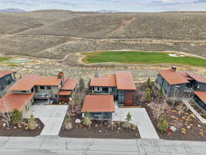 Aerial perspective of suburban area featuring a golf course and mountains