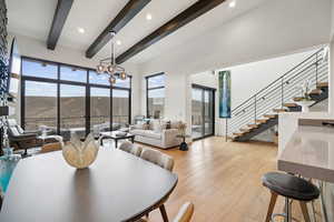 Dining space with light wood-type flooring, stairway, beamed ceiling, recessed lighting, and a chandelier