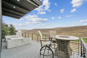 Wooden terrace with a fire pit, grilling area, and a mountain view