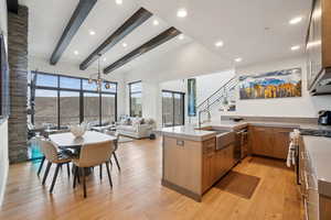 Kitchen featuring a peninsula, light wood-style floors, recessed lighting, brown cabinetry, and open floor plan