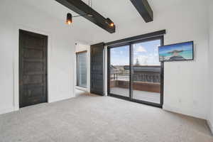 Unfurnished room with light colored carpet and beam ceiling