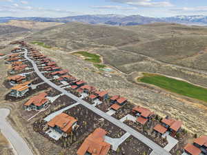 Aerial view of property and surrounding area featuring a mountain backdrop