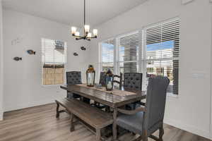 Dining space with light wood-style floors and a chandelier