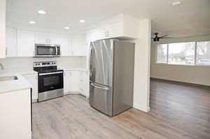 Kitchen featuring stainless steel appliances and white cabinets.