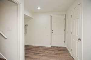 Laundry area with wood finished floors and baseboards