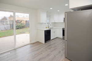 Kitchen featuring appliances with stainless steel finishes, white cabinets, light wood finished floors, and recessed lighting