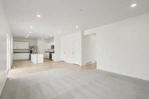 **DISCLAIMER** Interior colors & finishes may vary.Unfurnished living room featuring light colored carpet and recessed lighting