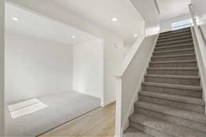 **DISCLAIMER** Interior colors & finishes may vary.Staircase featuring wood finished floors and recessed lighting