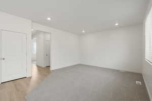 **DISCLAIMER** Interior colors & finishes may vary.Spare room featuring recessed lighting and light wood-type flooring