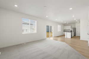 **DISCLAIMER** Interior colors & finishes may vary.Unfurnished living room with healthy amount of natural light, recessed lighting, and light wood-style floors