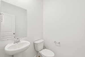 **DISCLAIMER** Interior colors & finishes may vary.Bathroom featuring toilet and a sink