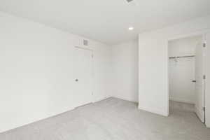**DISCLAIMER** Interior colors & finishes may vary.Unfurnished bedroom with a spacious closet, light colored carpet, and recessed lighting