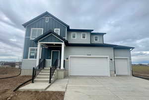 View of front facade featuring concrete driveway, board and batten siding, and an attached garage