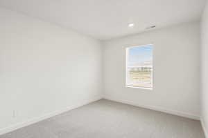 **DISCLAIMER** Interior colors & finishes may vary.Empty room with light carpet and recessed lighting