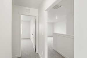 **DISCLAIMER** Interior colors & finishes may vary.Hallway with light colored carpet and baseboards