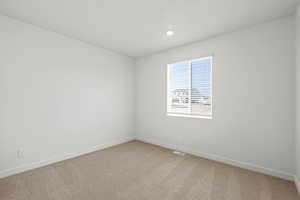 Unfurnished room with light colored carpet and recessed lighting