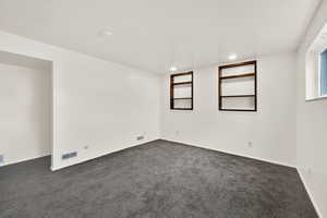 Unfurnished room featuring dark colored carpet and recessed lighting