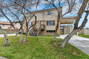 View of front of home with brick siding, a carport, and concrete driveway
