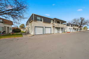 View of front of house featuring mansard roof, roof with shingles, a residential view, and a balcony