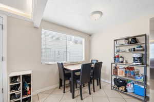 Dining room with light tile patterned flooring and a textured ceiling