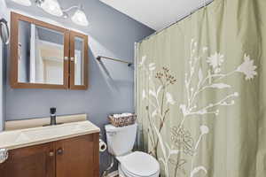 Full bathroom with curtained shower and vanity
