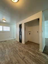 Laundry area with wood finished floors and baseboards