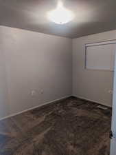 Empty room featuring dark colored carpet