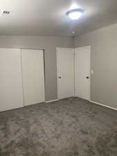 Unfurnished bedroom featuring a closet and carpet