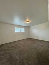 Unfurnished room featuring dark carpet