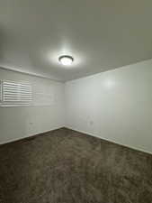 Unfurnished room with dark colored carpet