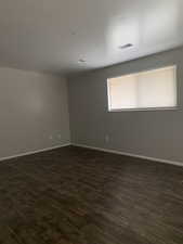 Empty room with dark wood finished floors and baseboards