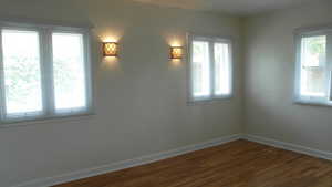 Apt # 10 > Spare room featuring dark wood finished floors and plenty of natural light