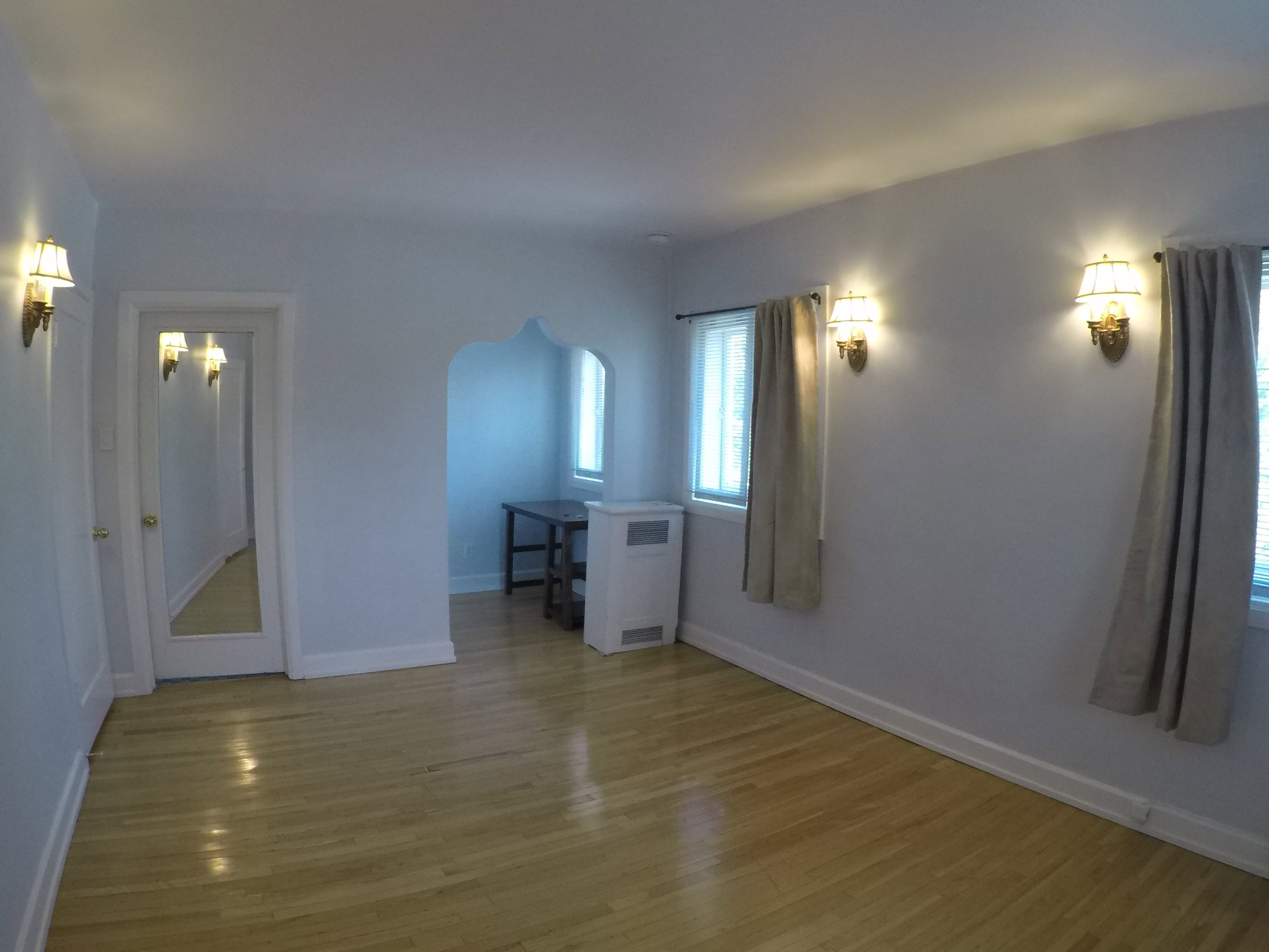 Apt # 15 > Unfurnished room with arched walkways and light wood-style floors