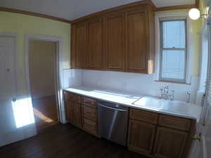 Apt # 4 >  Kitchen with dishwasher, light countertops, dark wood-style floors, crown molding, and brown cabinetry