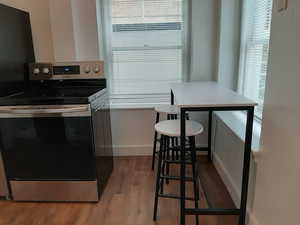 Apt # 16 > Kitchen featuring stainless steel range with electric stovetop and dark wood-style floors