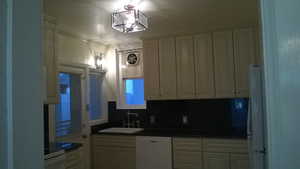 Apt # 1 Kitchen with dark countertops, white appliances, decorative backsplash, and crown molding