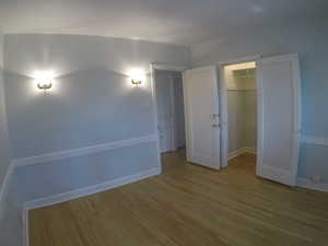 Apt # 15 > Unfurnished bedroom featuring wood finished floors and a spacious closet