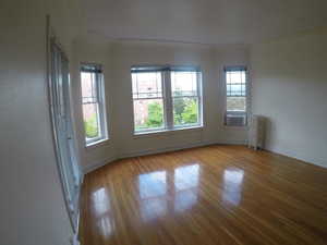 Apt # 4 >  Unfurnished room featuring wood finished floors and radiator heating unit