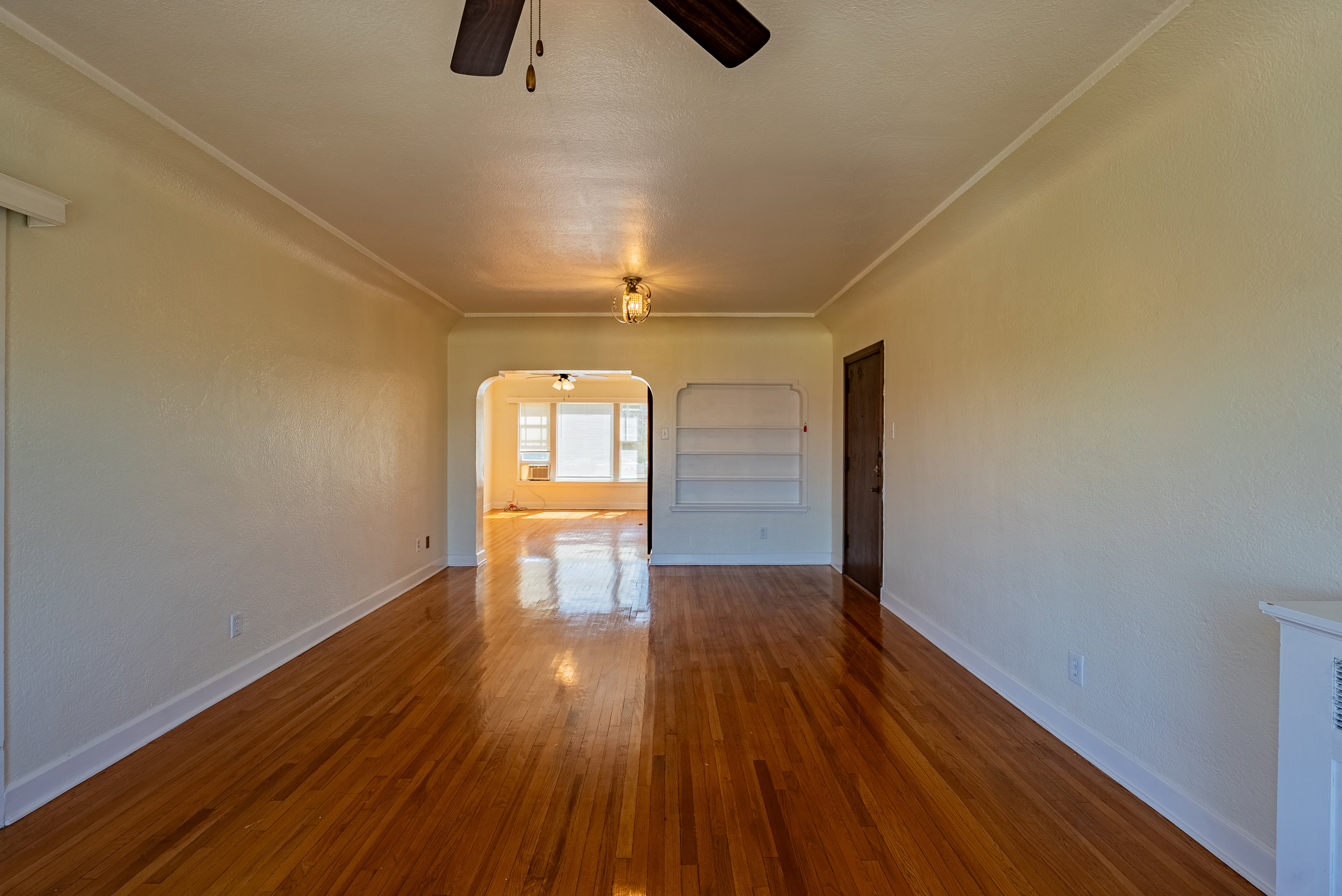 Polished wood-finish flooring extends throughout this expansive room
