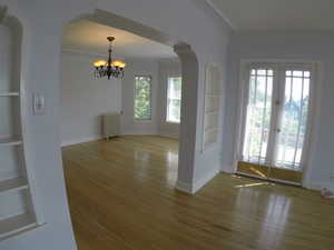Apt # 15 > Entrance foyer featuring arched walkways, a chandelier, radiator, hardwood / wood-style floors, and french doors