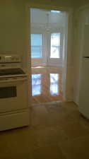 Apt # 10 > Kitchen with white appliances, a chandelier, light wood-style flooring, and white cabinetry