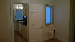 Apt # 1 Hall with radiator heating unit and light wood finished floors
