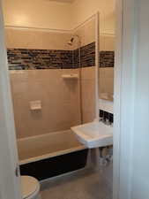 Apt # 16 > Full bath featuring washtub / shower combination and light tile patterned flooring