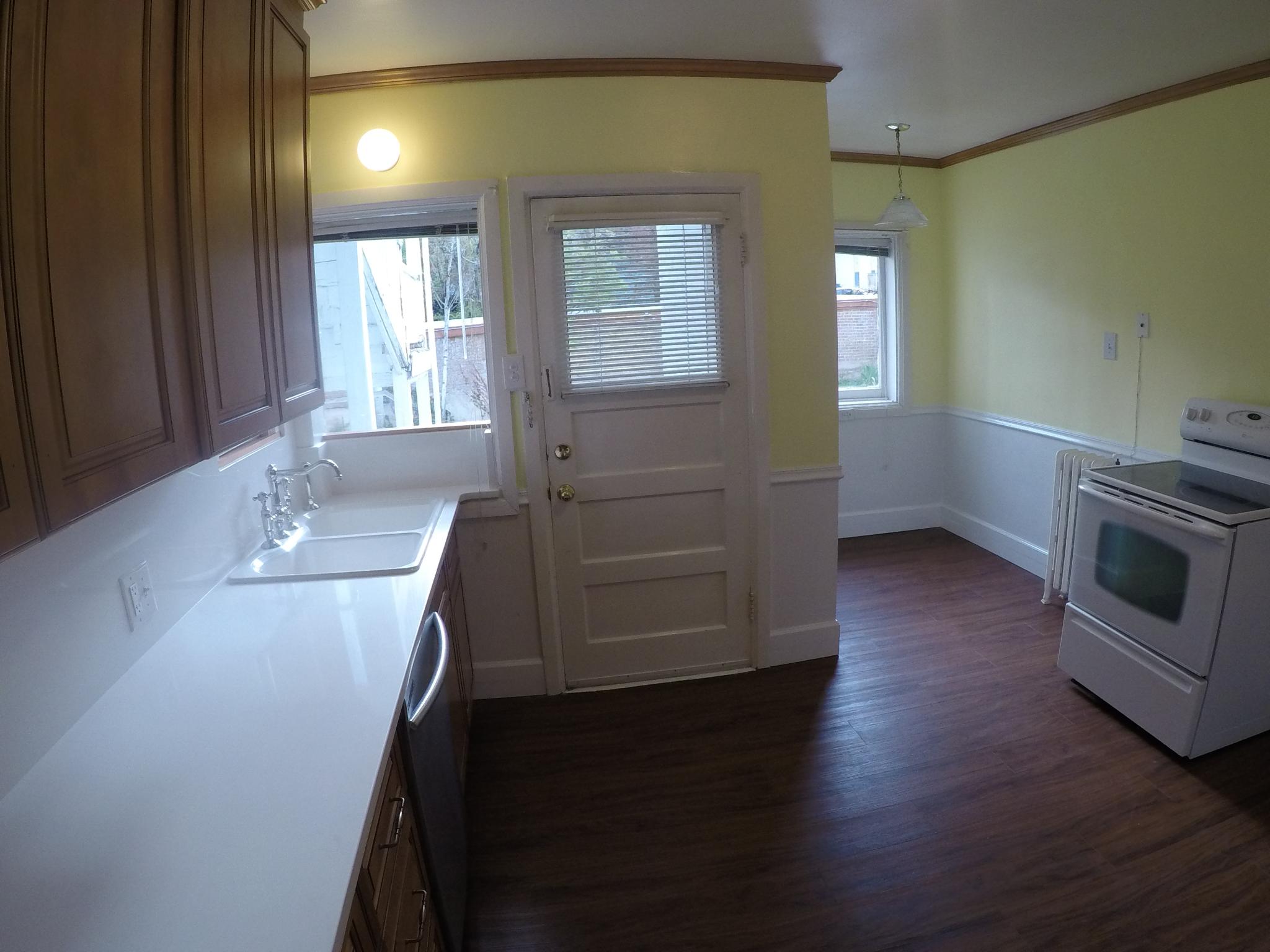 Apt # 4 >  Kitchen with white range with electric stovetop, light countertops, ornamental molding, dark wood-style flooring, and stainless steel dishwasher